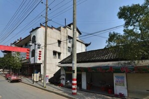 Vista de una calle con un edificio de estilo arquitectónico tradicional, un escaparate visible y un semáforo.