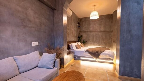 A modern room with a sofa, a bed, and a wooden coffee table.