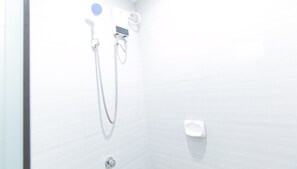 A shower with a handheld showerhead, a wall-mounted faucet, and a soap dispenser. - Reddoorz Plus @ D'builders Poblacion - Bgc (Taguig)