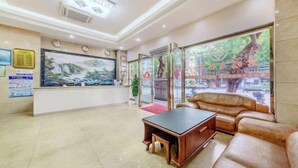 Un área de recepción con mostrador, zona de estar y amplios ventanales con vistas al exterior.