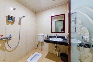 Un baño con inodoro, bidé, lavamanos y espejo.