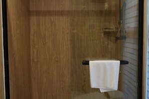 A wooden door leading to a shower area with a towel hanging on a rack. - Jinkai Shengyucheng Hotel Sihui (Sihui)