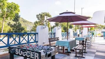 An outdoor seating area with tables, chairs, and a foosball table labeled 'SOCCER'.