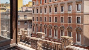 A view from a window overlooking a row of stone balustrades and buildings with arched windows and a consistent architectural style. - Apartment with Terrace on the Vatican Passetto (Roma)