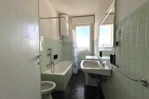 A small bathroom with a toilet, bathtub, and sink.