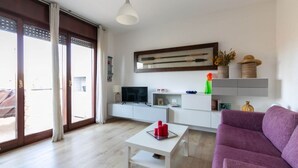 A modern living room with a sofa, a coffee table, and a television.