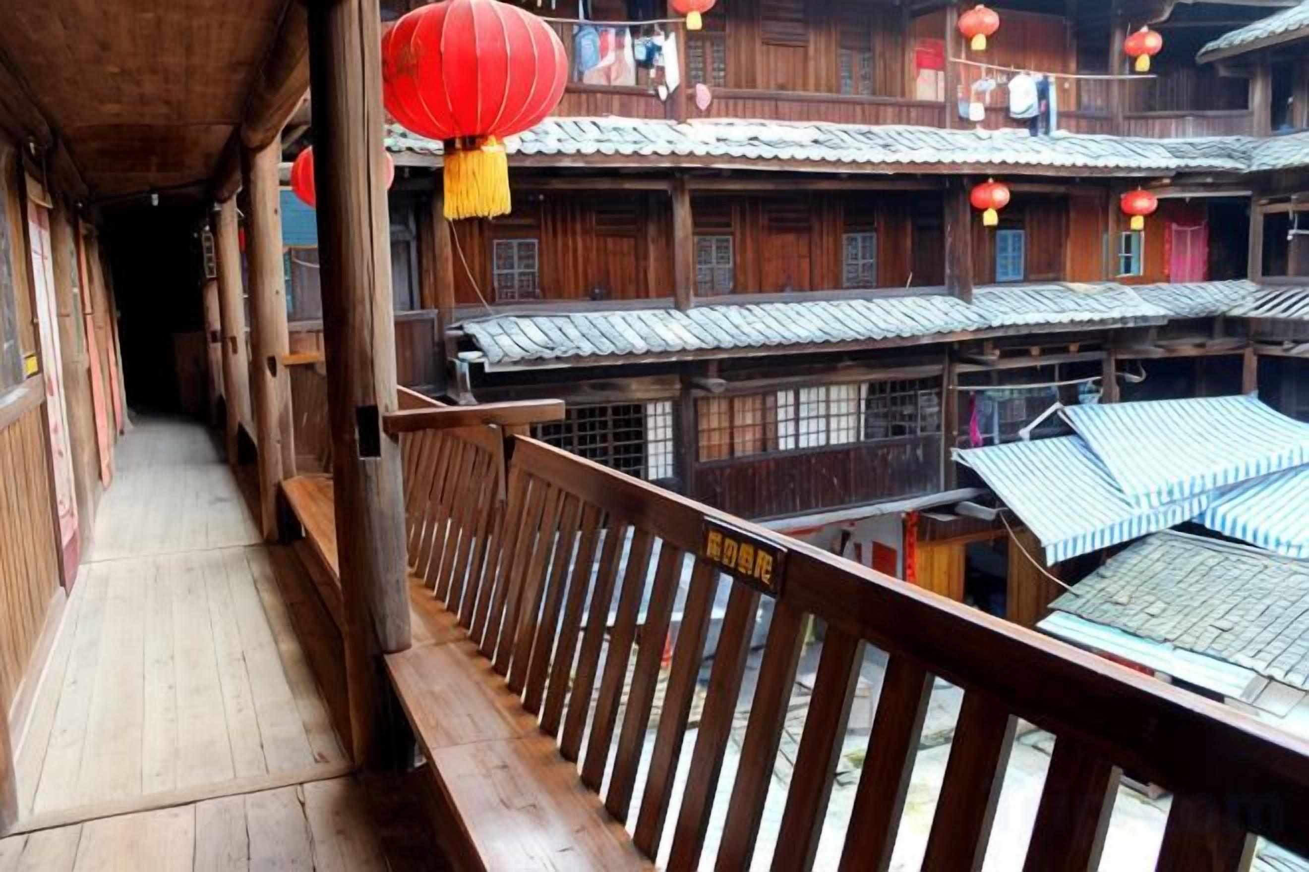 Un edificio de madera tradicional con varios balcones y faroles rojos.