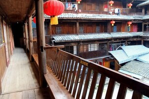Un edificio de madera tradicional con varios balcones y faroles rojos.