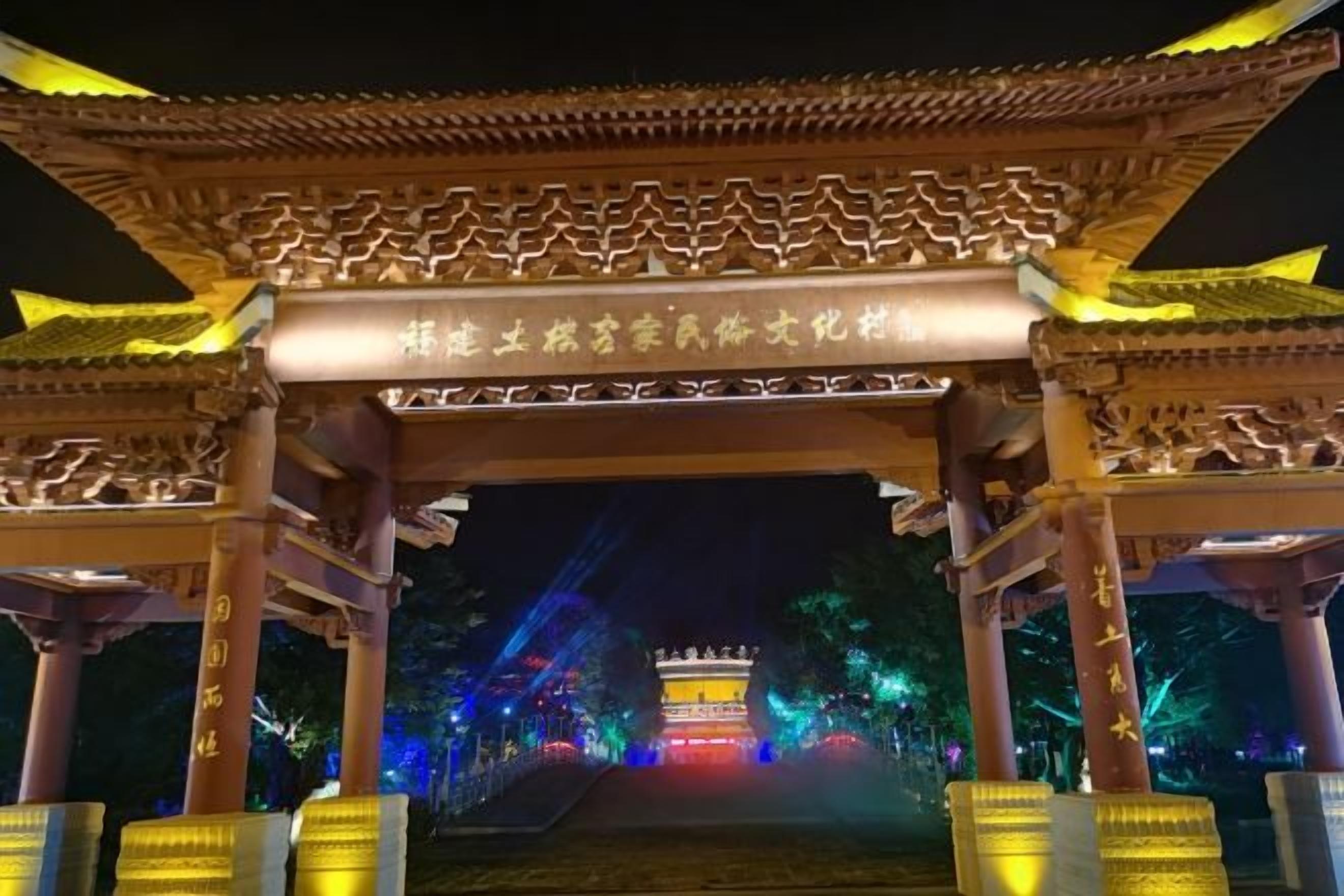A traditional Chinese pavilion with ornate roof and columns, illuminated by artificial lighting.