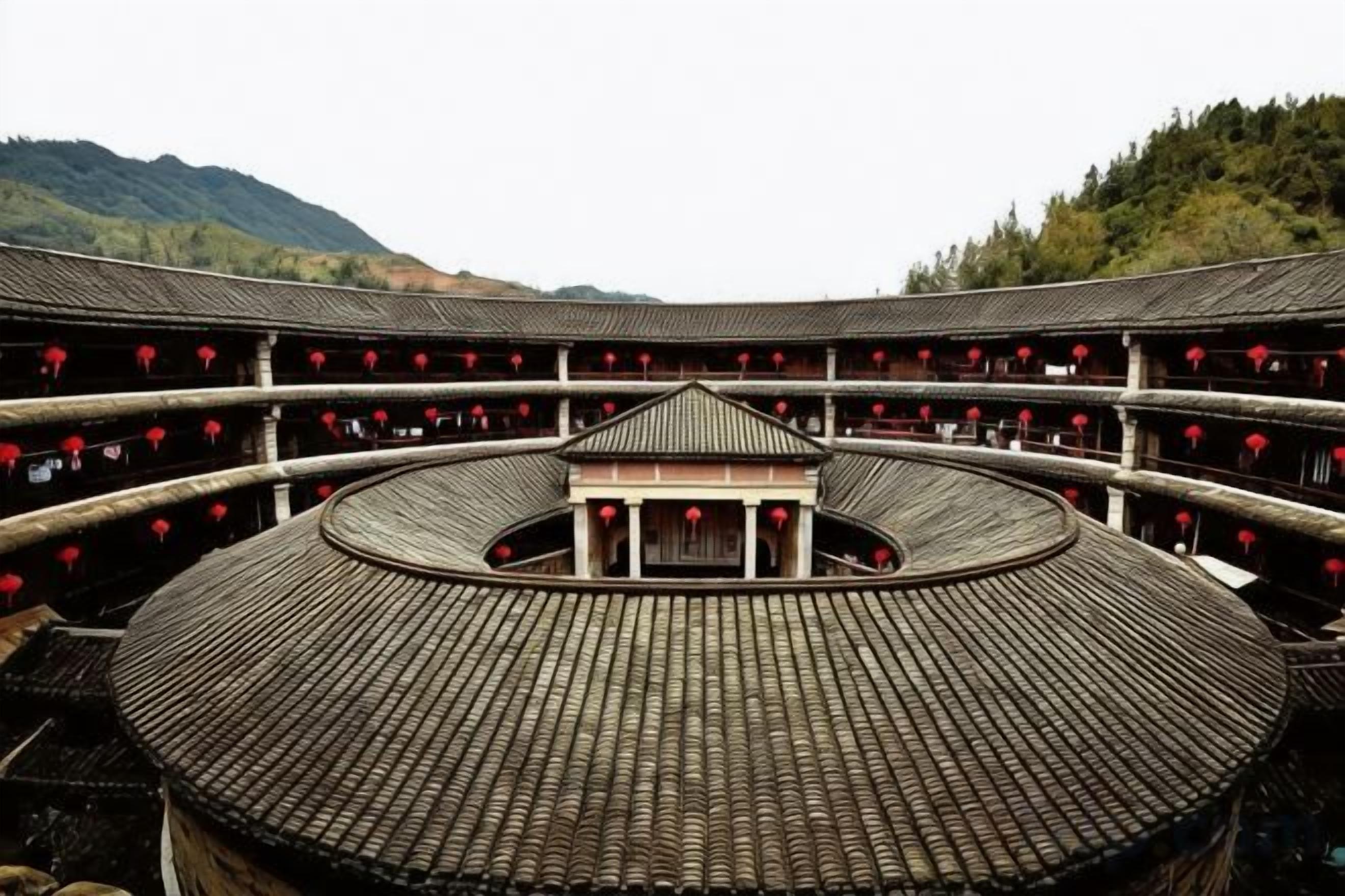 A traditional building with a circular central courtyard, multiple balconies, and a tiled roof.