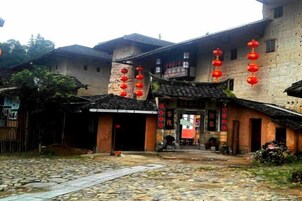 Un edificio tradicional con un patio, faroles rojos y un letrero.