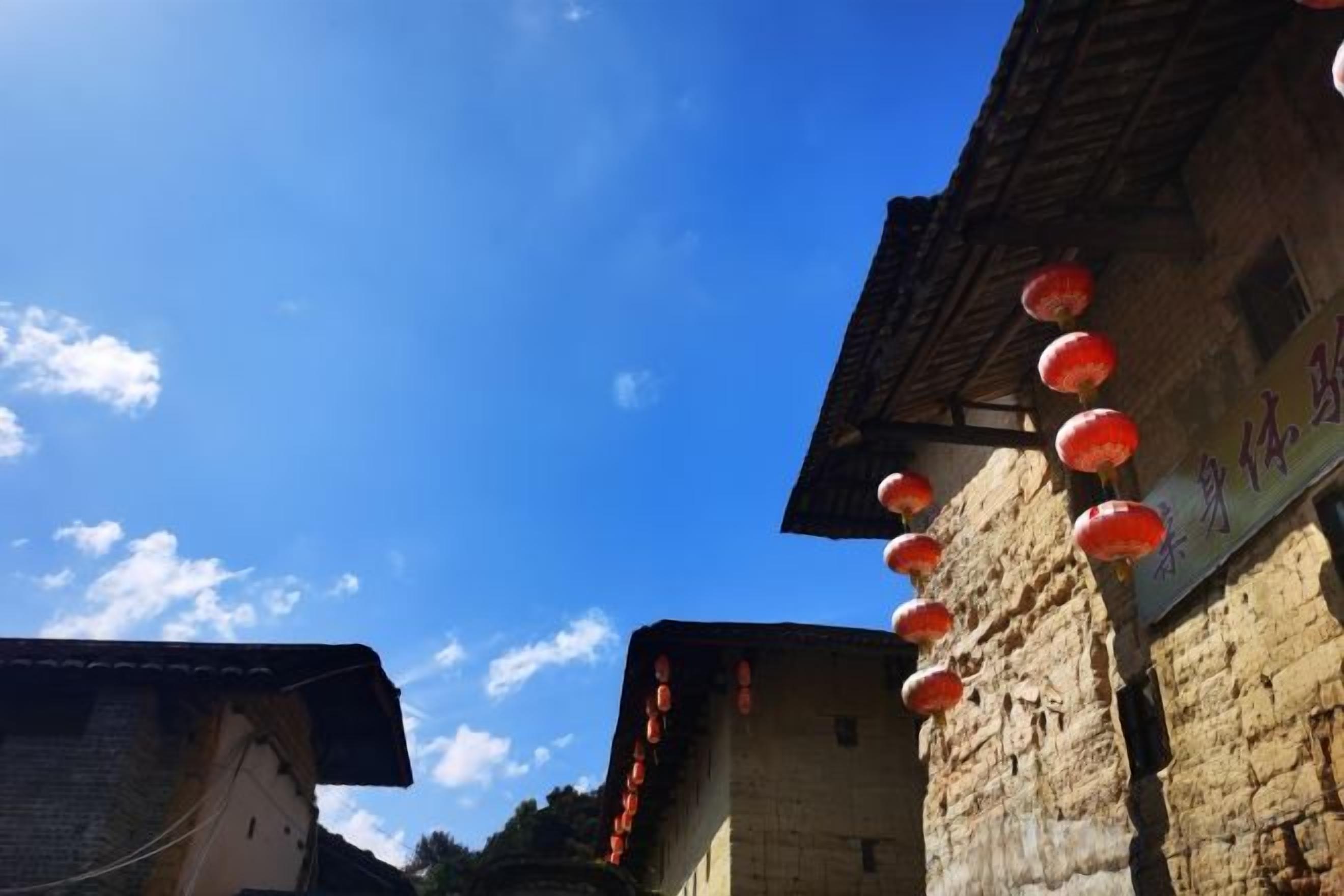 Un edificio tradicional con cielo azul claro y faroles rojos.