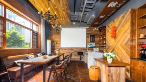 Un restaurant moderne avec des éléments décoratifs en bois, un bar et une grande fenêtre donnant sur un paysage verdoyant.