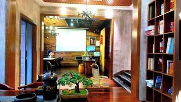 A cozy interior with a wooden floor, a small indoor garden, a bookshelf, and a dining area with a table and chairs.