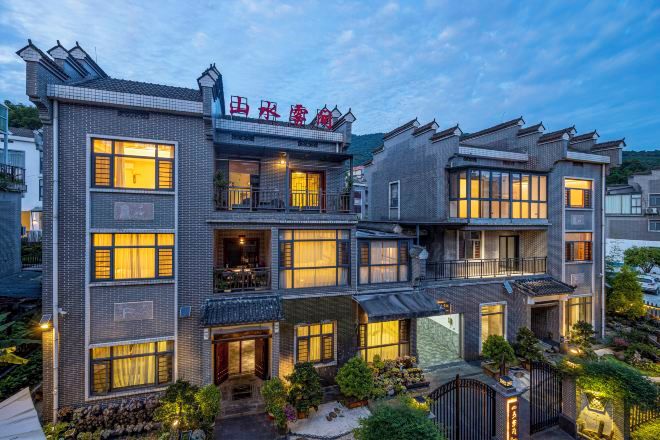 A multi-story hotel with a traditional architectural style, featuring balconies and large windows.