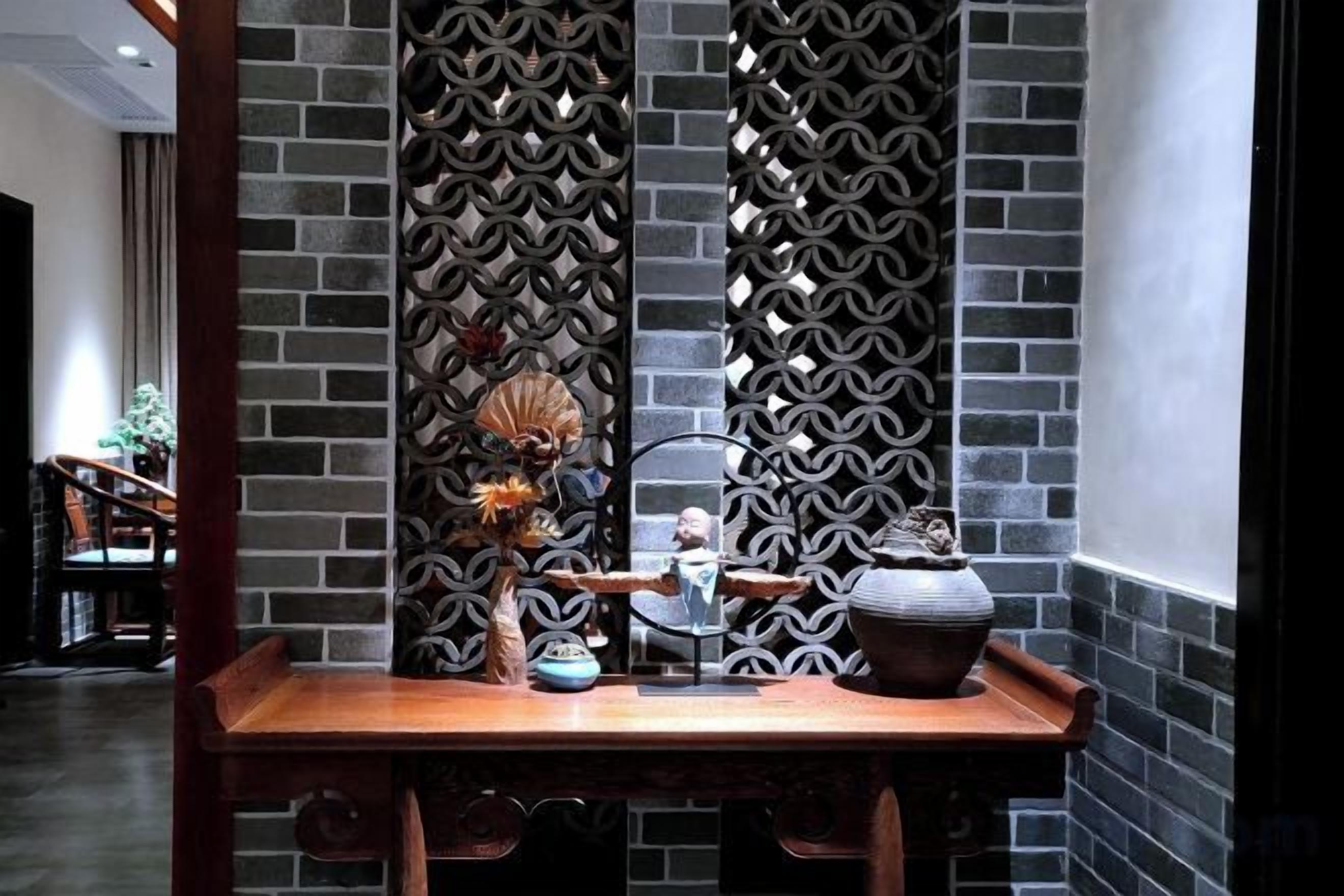 Un comedor con una mesa de madera, sillas y una pared decorativa con un diseño geométrico.