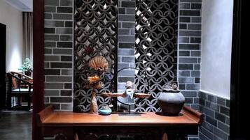 Un comedor con una mesa de madera, sillas y una pared decorativa con un diseño geométrico.