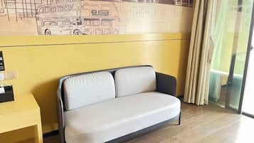 Una habitación con un sofá, una mesa amarilla y un mural de un autobús en la pared.