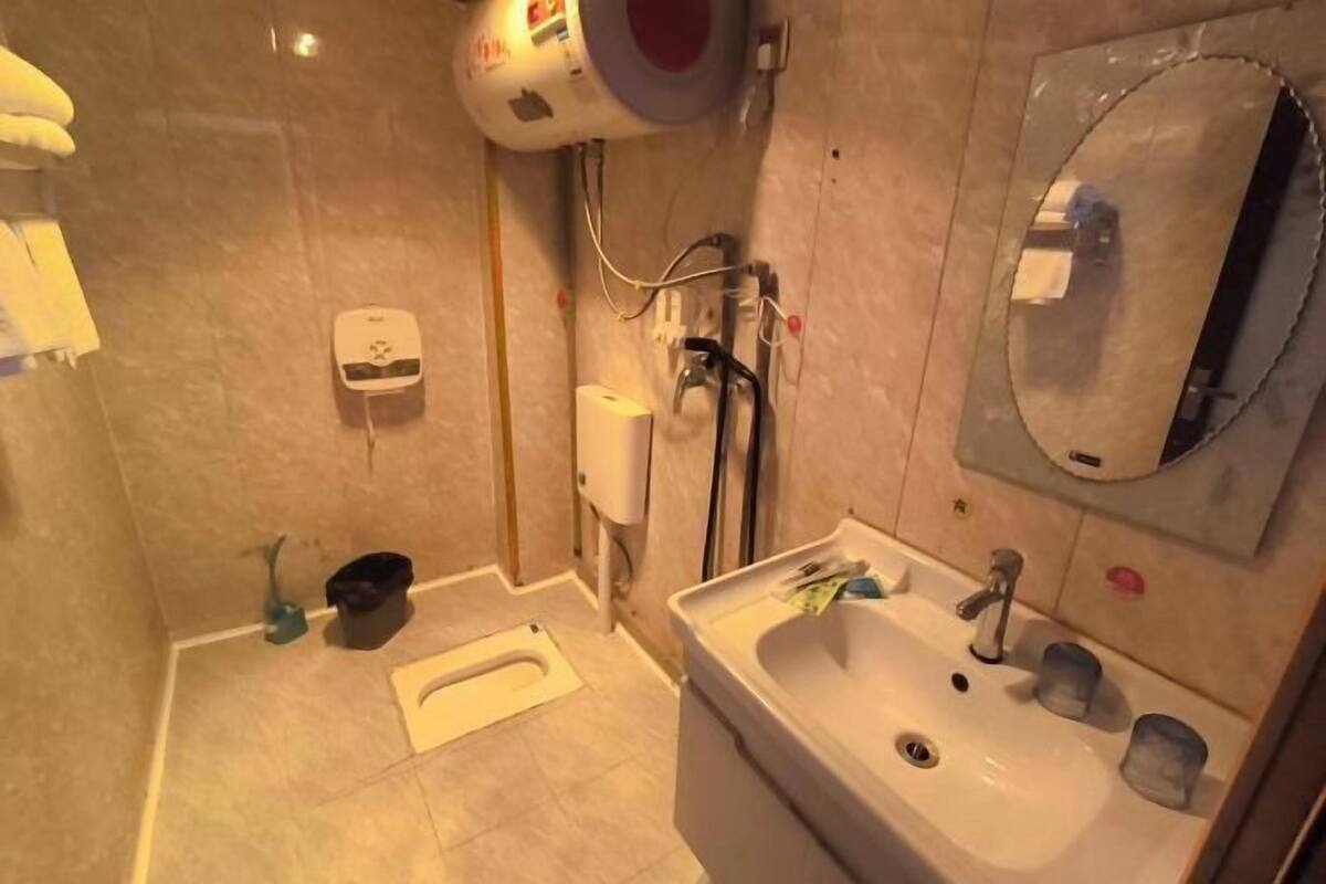 A bathroom with a sink, mirror, toilet, and shower.