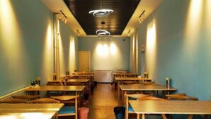 A long, narrow room with wooden tables and chairs arranged in rows. - Yinhe Hotel (Burqin)