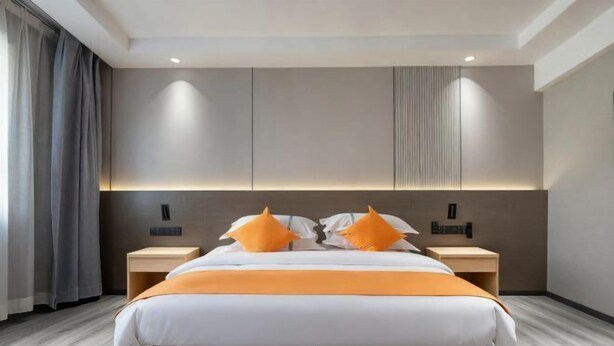 A modern hotel room with a large bed, two nightstands, and a headboard with built-in lighting. - Yinhe Hotel (Burqin)