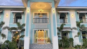 Un bâtiment à deux étages doté d’une entrée centrale, de balcons et d’un plafond décoratif.