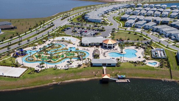 An aerial view of a resort with multiple swimming pools, a water park, and a residential area with houses. - Large 5BR Home w Pool, Princess Room, Resort Access (Kissimmee)