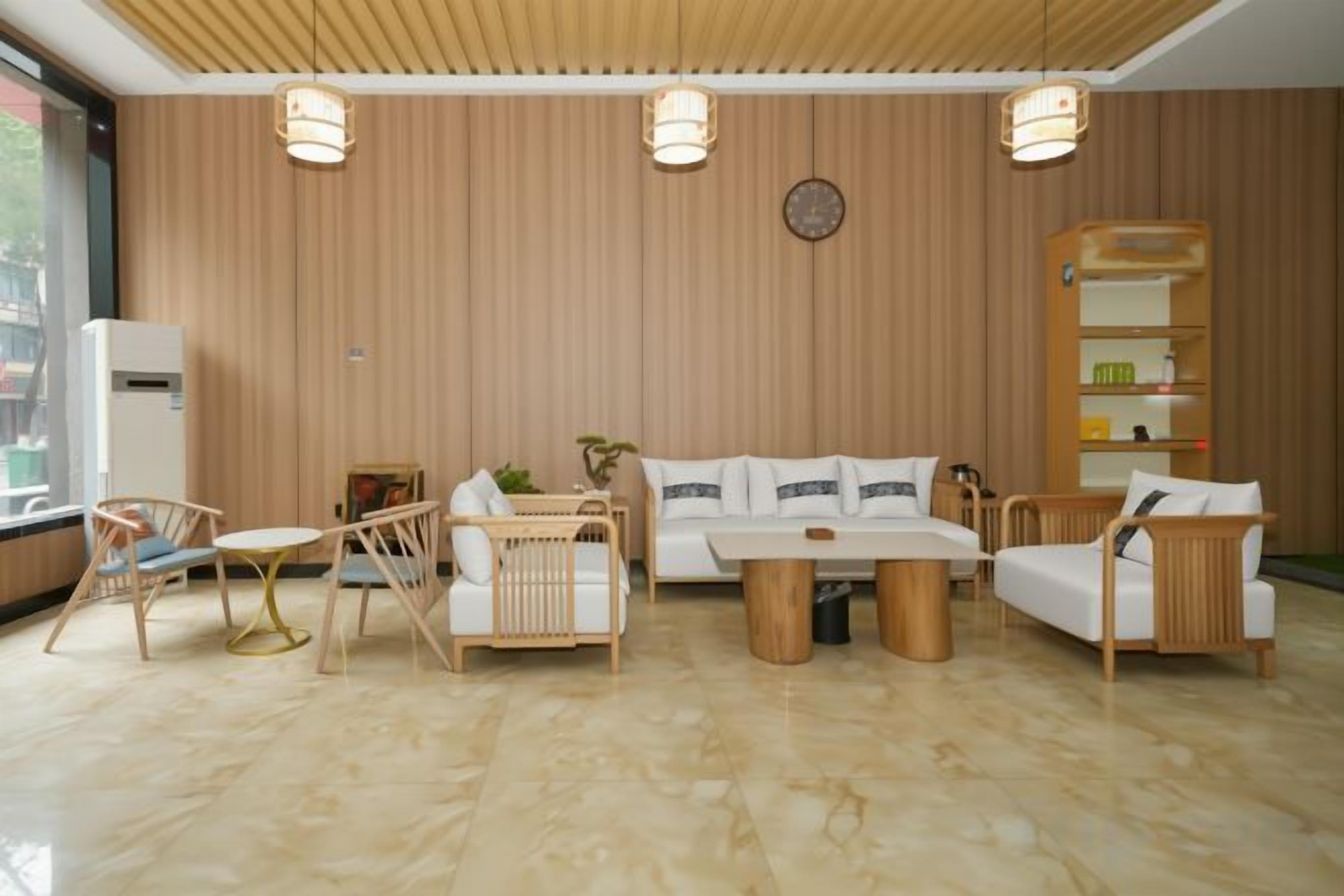 A modern living room with a sofa, two armchairs, a coffee table, and a bookshelf.