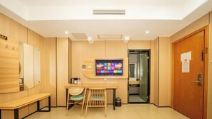 A hotel room with a wooden desk, a chair, a television, and a door. - Shankee Hotel (Nanchang Chengbihu Park) (Nanchang County)