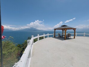 A gazebo with a table and chairs overlooking a coastal view. - Hotel Hanna Suites (Panajachel)