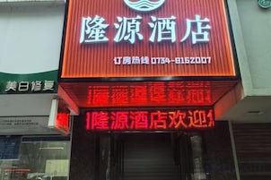 Un letrero de hotel con el nombre '隆源酒店' y una pantalla digital roja con caracteres chinos.