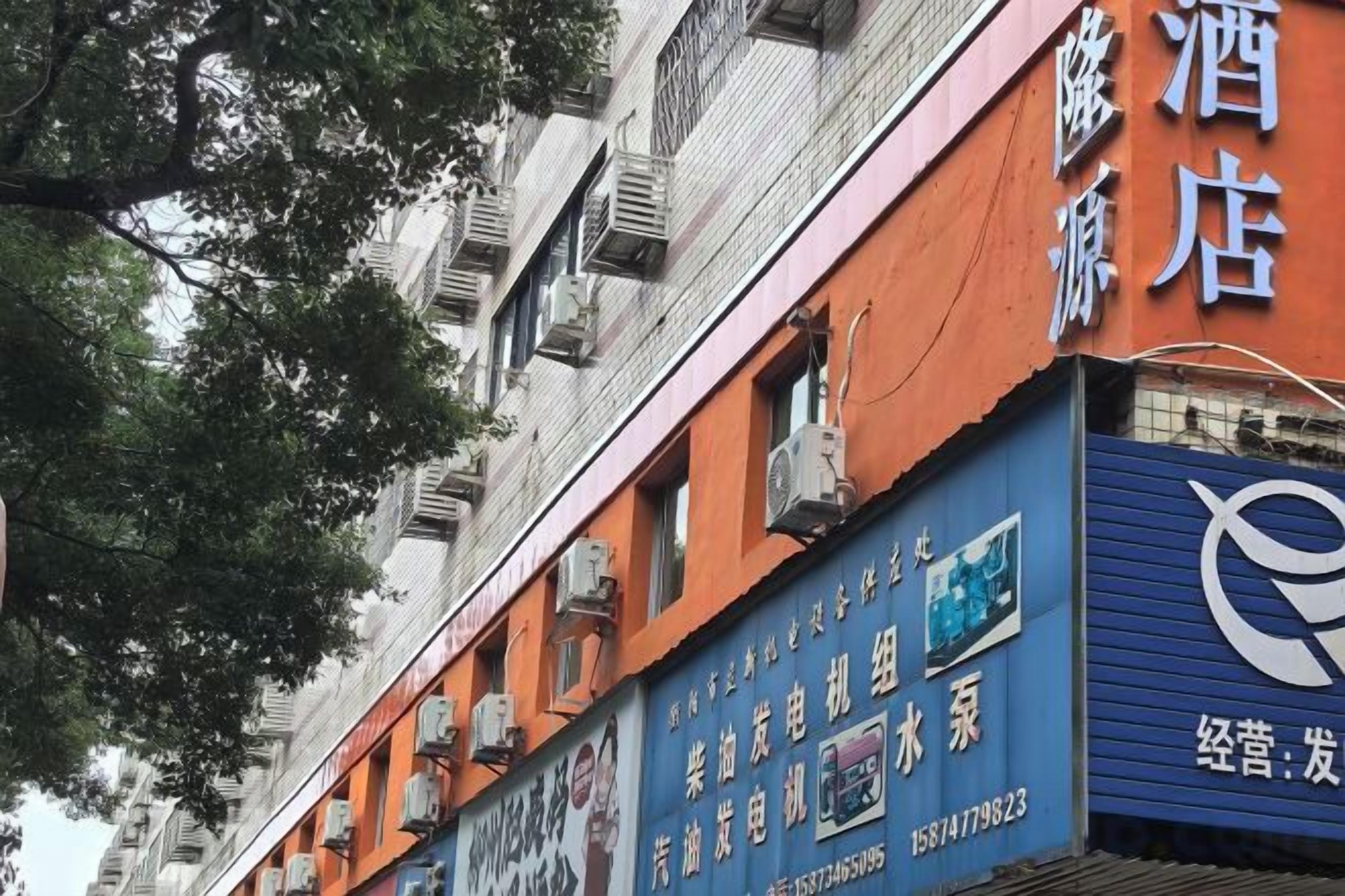 Um edifício com várias placas, incluindo uma para um hotel e outra para um estabelecimento comercial.