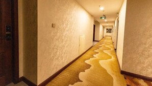 A long, narrow hallway with a patterned carpet and plain walls. - longdeguojifandian (Longde)