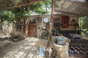 Un patio con un área de descanso techada, una bicicleta y un televisor.