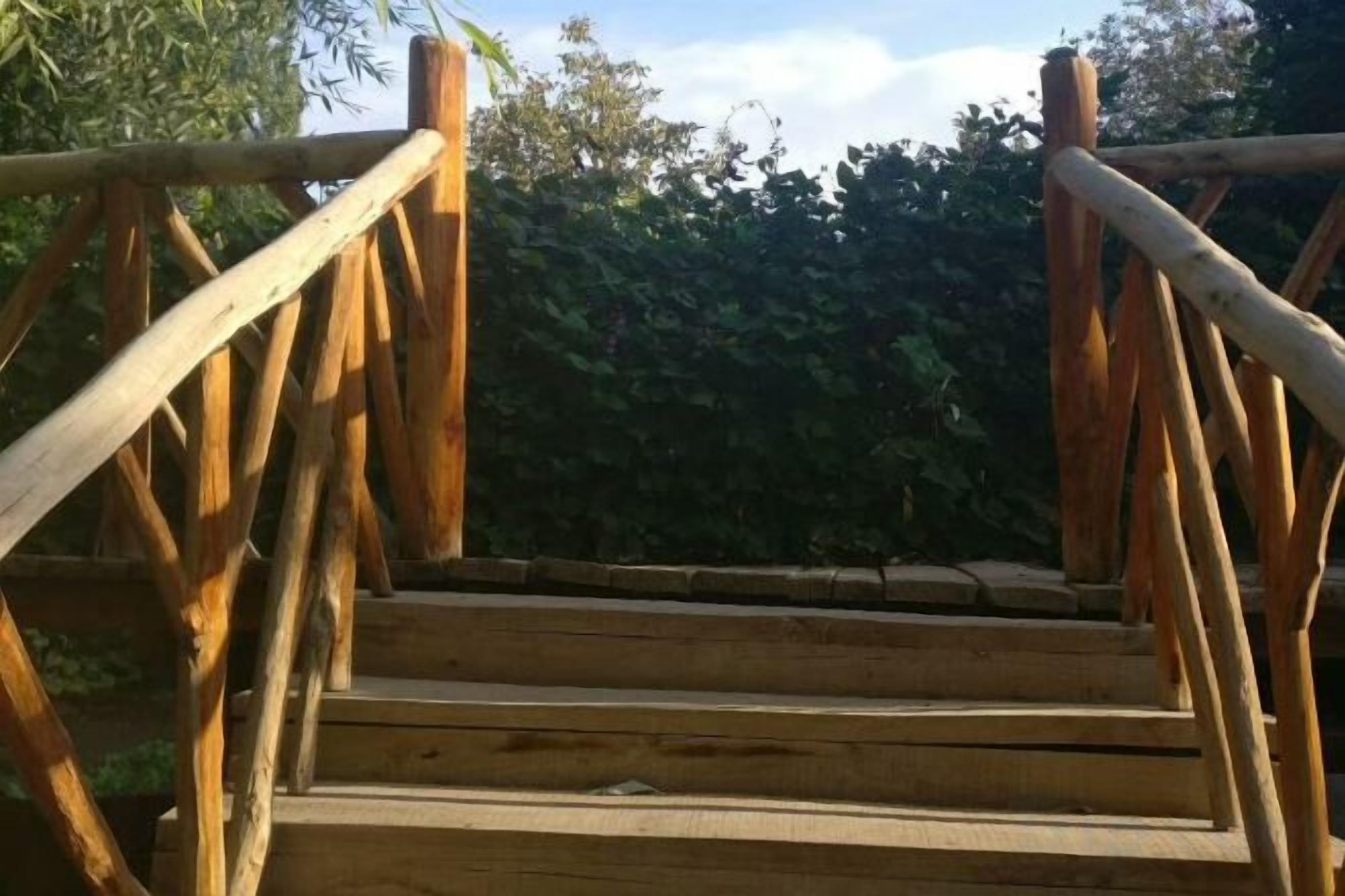 Een houten trap met een leuning die naar een hoger gelegen verdieping leidt.