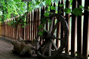 A wooden fence with a large wheel structure, a wooden post, and a log on the ground. - Anargvl Manor (Turpan)