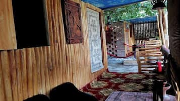 Een kamer met houten wanden, een kamerbreed tapijt, een bed en een klein tafeltje.