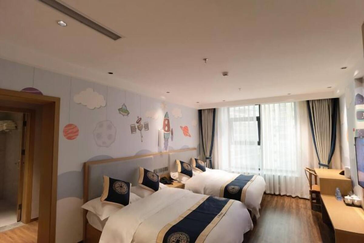 Habitación de hotel con dos camas, un escritorio y un armario.