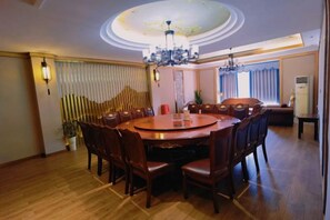 A dining area with a round table, chairs, and a chandelier. - Luocheng Fengxucheng Hotel (Luocheng)