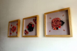 Trois œuvres d’art encadrées sont accrochées au mur.