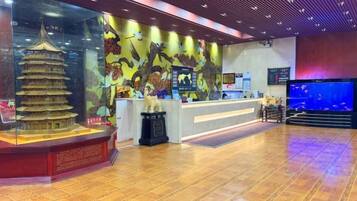 A reception area with a traditional pagoda model, a counter, and a large aquarium.