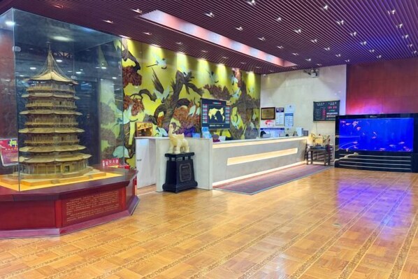 Un área de recepción con un modelo tradicional de pagoda, un mostrador y un gran acuario.