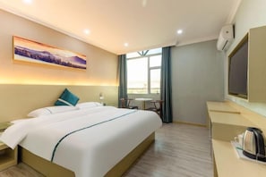 A hotel room with a bed, a desk, a chair, a TV, and a painting on the wall. - Guangzhou Jintan Fashion Hotel (Zhongluotan Subway Station) (Guangzhou)