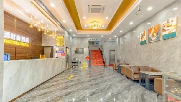 Eine Hotelhalle mit Marmorboden, einer Rezeption und einer Treppe zu den oberen Etagen.