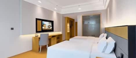 A modern hotel room with a bed, desk, chair, and a TV.
