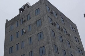 Un edificio alto y rectangular con varias ventanas y unidades de aire acondicionado.
