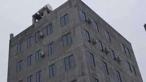Un bâtiment haut et rectangulaire, doté de nombreuses fenêtres et de plusieurs unités de climatisation.