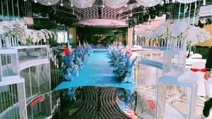 A hotel lobby with a central reflective pool, decorative arches, and a blue carpet. - Huasheng Shaxian Boutique Hotel (Sanming)