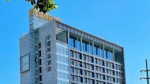 A modern hotel building with a glass facade and multiple floors. - Huasheng Shaxian Boutique Hotel (Sanming)