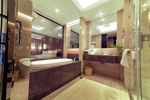 A modern bathroom with a large bathtub, a separate shower area, and a vanity with a mirror. - Huasheng Shaxian Boutique Hotel (Sanming)